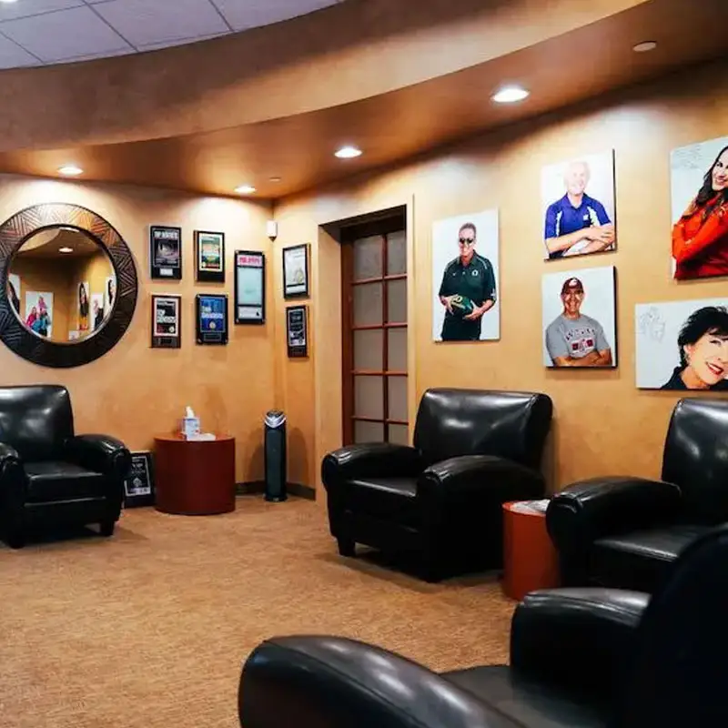 Reception area with 4 chairs with images and awards on the wall at GOREgeous Smiles 