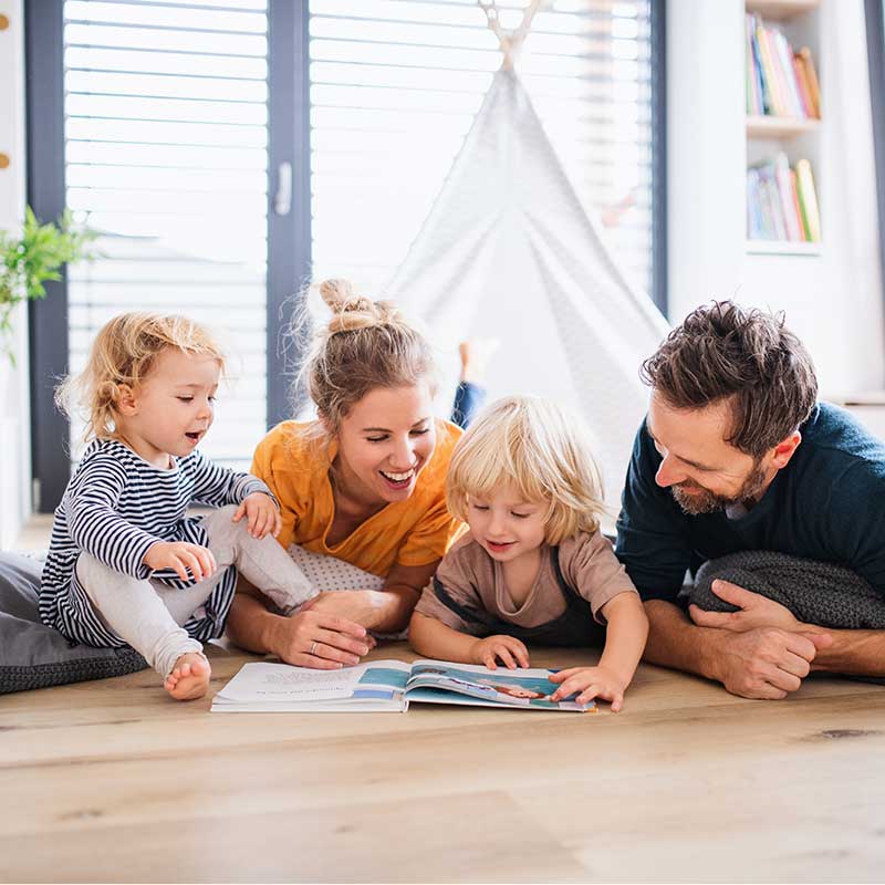 A happy family smiling and reading a book together 