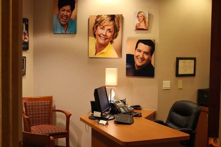 A consult room with images and awards on the walls.