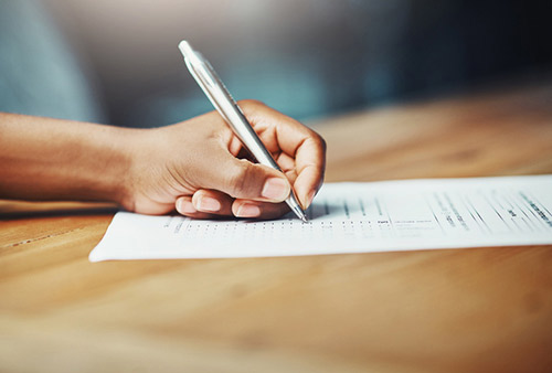 Close up of patient hands filling out a form